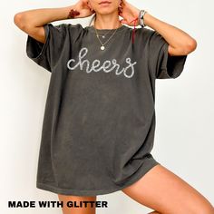 Our glitter Cheers shirt makes the perfect addition to your holiday collection. You will love it! Also makes a great gift! Please note: If you would like an oversized t shirt dress look then please consider ordering at least two sizes up from your normal size. Feel free to reach out if you have any questions.  HOW TO ORDER  1. Select the size and color of the shirt you would like to order. 2. Add the quantity of shirt(s) you would like and then click "Add to Cart" 3. Submit Order  4. During checkout please provide any additional information in the "Note to Seller" section. If you forget, just send me a message on Etsy after your order is completed.  GLITTER CHEERS SHIRT DETAILS  This listing is for a comfort colors® crewneck unisex t-shirt. This tee is a heavy duty cotton tee. It is made o Group New Years Shirts, Trendy Slogan Tops For Party, Trendy Party Tops With Slogan, Casual Slogan Tops For Party, Casual Party Tops With Slogan, Short Sleeve Cotton Party Top, Cotton Short Sleeve Party Tops, Party Cotton Top With Short Sleeves, Casual Party T-shirt With Text Print