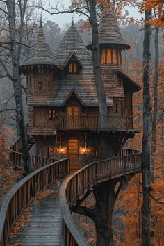 a tree house in the middle of a forest with stairs leading up to it's roof