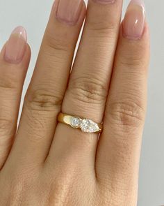 a woman's hand with a diamond ring on her left and the middle finger