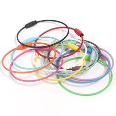 several different colored bracelets on a white background