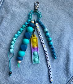 three different colored beads are attached to a keychain on a blue jean jacket