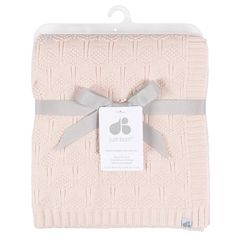 the baby blanket is pink and has a gray ribbon around it's edge, with a tag that says just born