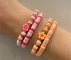 three bracelets with flowers on them sitting on a person's arm