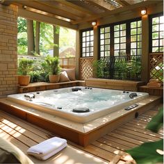 a large hot tub sitting on top of a wooden floor next to a planter