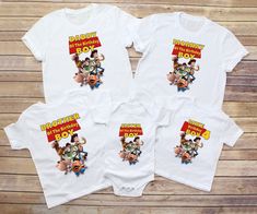 three white onesuits with cartoon characters printed on the front and back, sitting next to each other