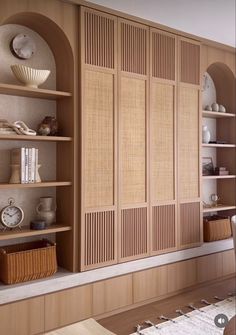 a living room with wooden shelves filled with books and vases on top of them