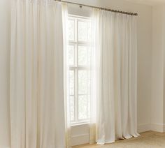 a white curtain hanging in front of a window