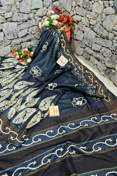 Get a new look every time with IndyVogue, like with this tussar silk with hand batik work. Available in graphite black color with amazing hand embroidery work of kantha and Gujarati stitch mixed to design a beautiful pallu and border along with hand batik work on the whole body spread unanimously. The zari work on the pallu and the border in a stacked pattern gives it a different touch. Color: A shade of graphite black color Technique: Body with hand batik work with border and pallu has Kantha & Gujarati stitch embroidery with zari work Fabric: Tussar Silk Quality: IndyVogue's Assurance of Silk Mark Certified Black Embroidered Silk Saree, Black Silk Embroidered Saree, Black Silk Traditional Wear Embroidered, Black Tussar Silk Traditional Wear With Resham Embroidery, Black Tussar Silk Saree With Resham Embroidery, Black Silk Bohemian Dupatta, Embroidered Black Tussar Silk Traditional Wear, Black Embroidered Tussar Silk Traditional Wear, Black Embroidered Tussar Silk Dupatta