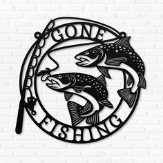 the gone fishing sign is mounted on a brick wall, with two fish in it