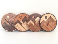 four wooden coasters with mountains on them