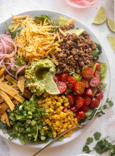 a white plate topped with taco salad and tortilla chips next to salsa