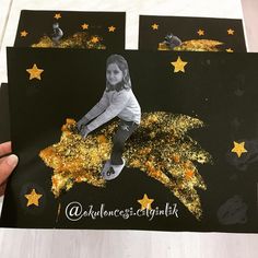 someone is holding up some black and gold glittered cards with a girl on it