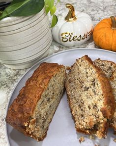 slices of banana bread on a white plate next to pumpkins and other fall decorations