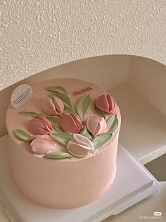 there is a pink cake with flowers on it