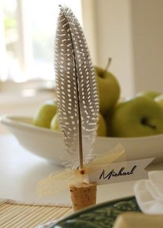 a table topped with green apples and white feathers