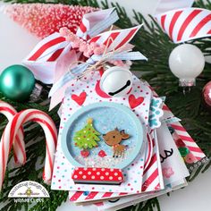 a christmas ornament on top of a table with candy canes and ornaments