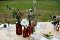 there are many vases with flowers in them on the table together, and one is empty