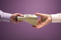 two people shaking hands with money in each other's hand on a purple background