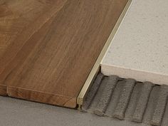 a close up of a wooden door on the side of a building with concrete and wood flooring