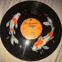 a record with two koi fish painted on it