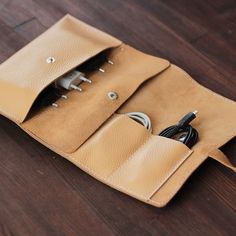 an electronic device in a leather case on a wooden floor with wires plugged into it