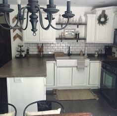 a kitchen with white cabinets and black appliances