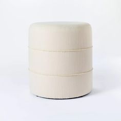 a white ottoman sitting on top of a white floor