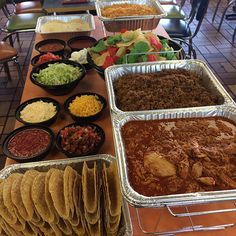 a buffet table filled with lots of different foods and condiments on trays