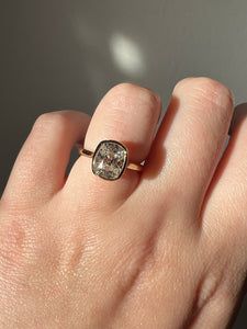 a woman's hand with a ring on it that has a diamond in the middle