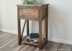 a small wooden table with a book on it and a plant growing out of the top