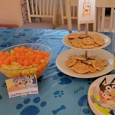 a table topped with plates and bowls filled with food next to a sign that says charlie the pooh