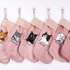 five stockings with cats on them hanging from hooks