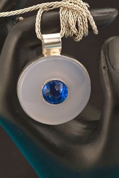 How about a gem inside a gem? This is the perfect layering necklace. Our one-of-a-kind Medallion pendant features a Portuguese cut blue quartz in the center of the Chalcedony stone. This is a bold piece of jewelry! The center bezel holding the Blue Quartz is handmade and welded to the Argentium silver back piece. This is totally 100% hand carved and handmade by us! We do not think we've seen the marriage of faceted gemstone & cabochons together in one piece before. This is totally 100% handmade Boho Necklace Layering, Back Piece, Green Amethyst Ring, Custom Wedding Band, Chalcedony Stone, Bold Jewelry, Gemstone Cabochons, Jewelry Picture, Medallion Necklace