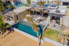 an aerial view of a house with a pool and palm trees in the foreground