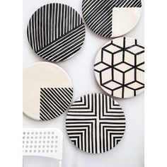 four black and white plates with geometric designs on them, sitting next to each other