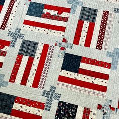 an american flag quilt is displayed on a table topper with red, white and blue squares