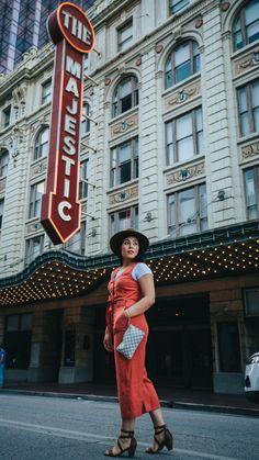 a woman is standing in front of the marquee sign for the majestic theatre