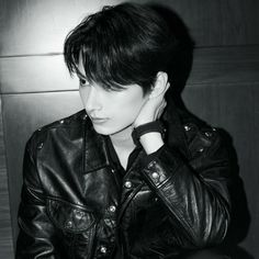 black and white photograph of a woman wearing a leather jacket with her hand on her head