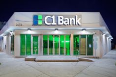 the front entrance to a bank building lit up at night