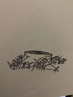 a piece of paper with black ink on it and some grass in the foreground