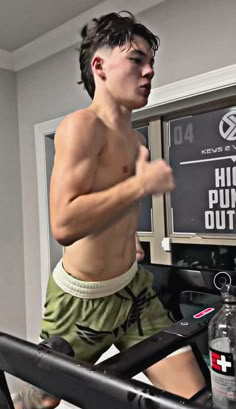 a shirtless man running on a treadmill