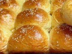 several rolls with sesame seeds on them in a baking pan