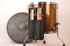 a drum case with sticks and drumsticks in it sitting next to an instrument