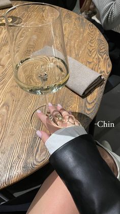 a woman is sitting at a table with a glass of wine