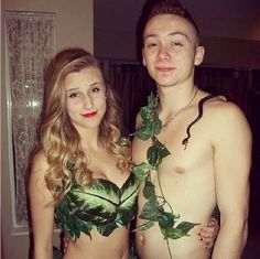 a man and woman dressed up in leafy clothing posing for the camera with leaves on their chest