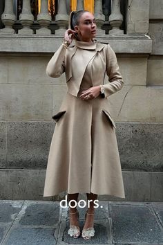 While revisiting the famous trench coat, the designer gives her own version with all the hallmarks of the original including military-inspired epaulettes and featuring tortoiseshell buttons in a woven version. Mid-calf length. Layered trench coat featuring long sleeves, a front button fastening. Layered collar detail. Side flap pockets. Asymmetric hem draping down either side. Designed by GR LONDON PARIS, a young London based Fashion House. Grab this coat at doors.nyc and #supportTALENT