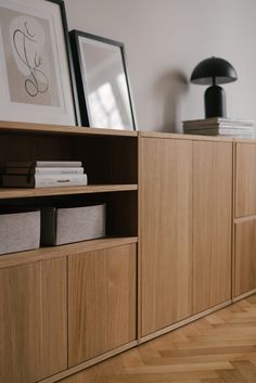 a book shelf with books and pictures on it in a room that has wood floors