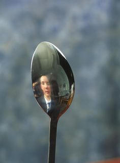 a reflection of a man in a mirror on a spoon