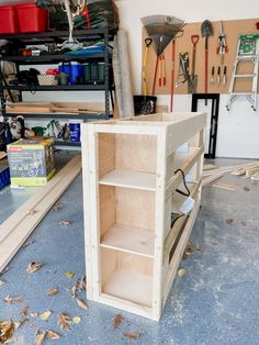 a workbench in a garage with tools hanging on the wall and wood shelves