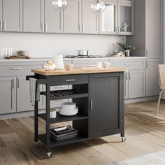 a white kitchen island with wooden top in a room next to a dining table and chairs